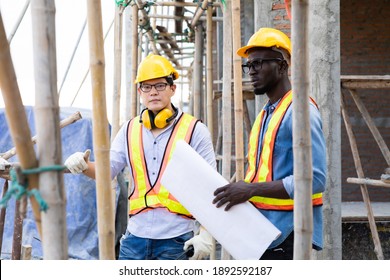 Professional Construction and  Engineer team Working on workplace. Professional black architect and construction worker working look at blueprint plan on site.