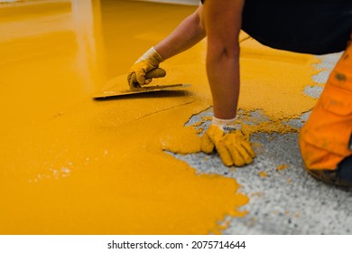 Professional Construction Worker Applying Floor Paint Or A New Layer For A Epoxy Cast Coating Floor