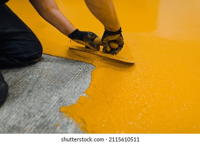 Professional Construction Worker Applying Floor Paint Or A New Layer For A Epoxy Cast Coating Floor