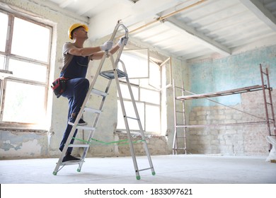 Professional constructor on ladder in old building - Shutterstock ID 1833097621