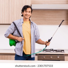 Professional contractor doing pest control at kitchen