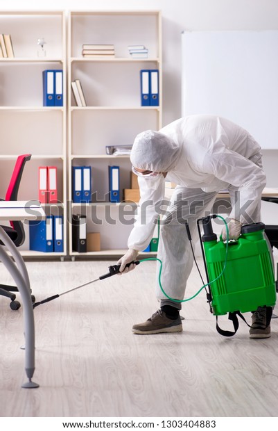 Professional\
contractor doing pest control at office\
