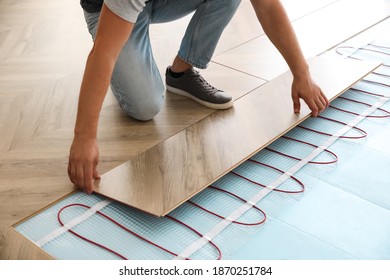 Professional Contractor Installing Underfloor Trace Heating System Indoors, Closeup