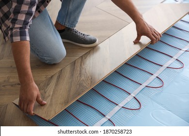 Professional Contractor Installing Underfloor Trace Heating System Indoors, Closeup