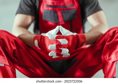 Professional Contractor Worker In A Red Uniform And Safety Gloves Awaiting Next Tough Job Concept Photo.