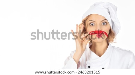 Professional cook in chef hat and uniform with mustache from red hot chili pepper. Spicy food concept. Chili pepper for seasoning. Woman chef with vegetables in kitchen. Copy space for advertising.