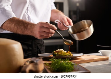Professional cook in uniform add some spices to dish, decorating delicious meal for guests in hotel restaurant. food, cooking concept - Shutterstock ID 1927957934