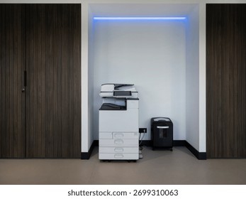 Professional copy machine and document shredder in minimalist office alcove with blue accent lighting