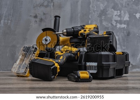 Professional cordless tool set. Angle grinder, screwdriver and impact wrench with batteries and tool box. Concept for construction, repair, renovation and DIY projects