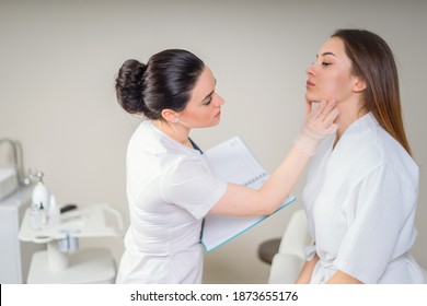 Professionelle Kosmetikerin, die die Gesichtshaut von Mädchen in der Klinik der ästhetischen Kosmetologie