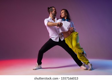 Professional Couple Of Dancers Passionately Performing Expressive Dance, Looking Away, Pay No Attention To Audience, Modern Style Dancers In Studio Full Of Light