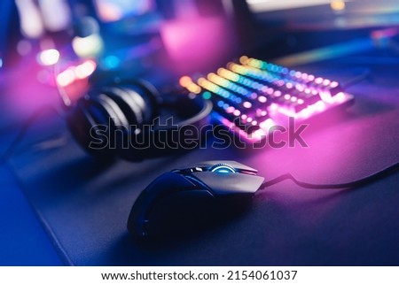 Professional cyber video gamer studio room with personal computer armchair, keyboard neon color. Soft focus blur background.