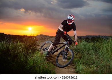 Professioneller Radfahrer Reiten Sie das Bike auf dem Mountain Rocky Trail bei Sunset. Extremsport