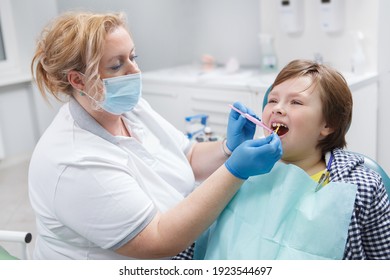 Professional Dentist Giving Fluoride Dental Treatment To A Young Boy