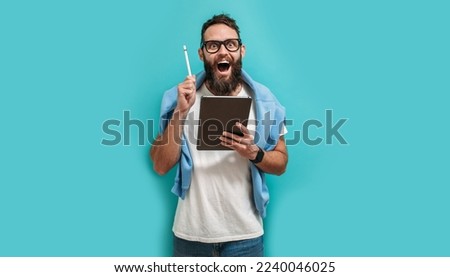 Professional designer working on digital tablet computer using stylus pen isolated over blue color background.
