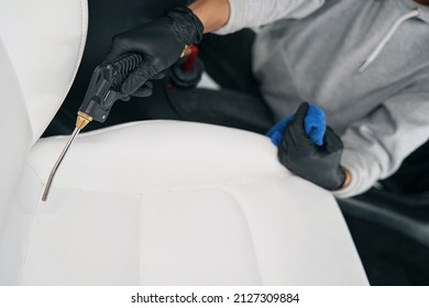 Professional Detailer Drying Automotive Seat Seams With Compressed Air