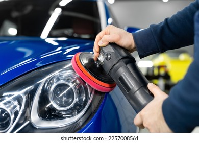 Professional detailing a car in car studio, hands with orbital polisher, scratching remover, vehicle care concept - Shutterstock ID 2257008561