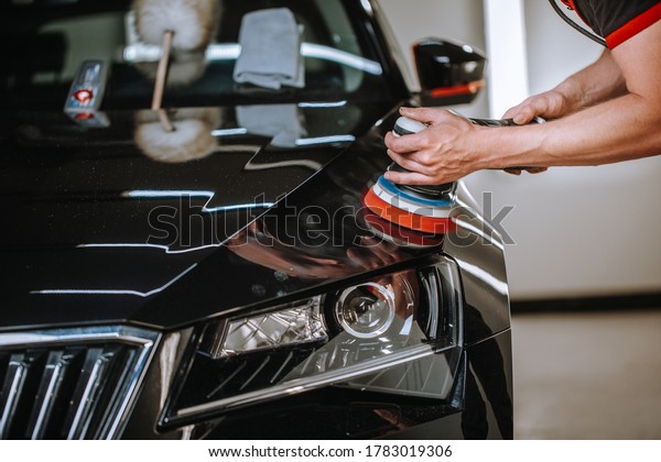 Professional\
detailing a car in car studio, hands with orbital polisher,\
scratching remover, vehicle care\
concept