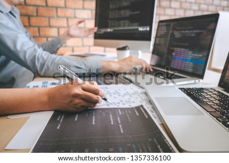 Professional Developer programmer cooperation meeting and brainstorming and programming in website working a software outsourcing and coding technology, writing codes and database.