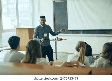 Professional Development Workshop. Young man, tutor leading workshop for group of involved students. Well-lit classroom. Concept of education, youth, workshop, knowledge - Powered by Shutterstock