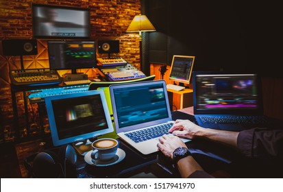 professional director, editor, producer editing movie footage and music score track on computer in digital editing, post production, broadcasting studio