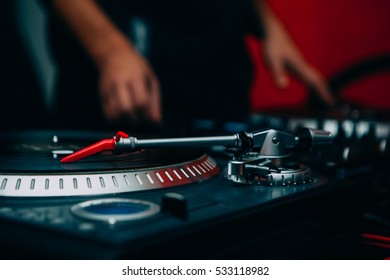 Professional Disc Jockey Audio Equipment On Stage In Night Club.Dj Turn Table Gear For Hip Hop Party.Pro Sound System For Parties.Red Turntable Needle On Black Vinyl Record