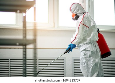 professional disinfector in protective suit holding chemical sprayer and other equipment for sterilization and decontamination of viruses, infectious diseases. coronavirus, COVID-19 epidemic concept - Shutterstock ID 1694213737