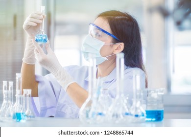 Professional distinguished Science specialist at work.Young Asian scientist with test tube making research in clinical laboratory.Innovative technologies in science and medicine