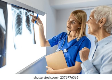 Professional doctor explaining lungs x-ray film about coronavirus covid-19 infected on screen to senior female patient at lab. Doctor showing chest x-ray to female patient. - Powered by Shutterstock