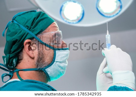 professional doctor holding general anesthetic medicine or antiviral drug vaccine needle syringe for patient before surgery in the operating room at the hospital. ストックフォト © 