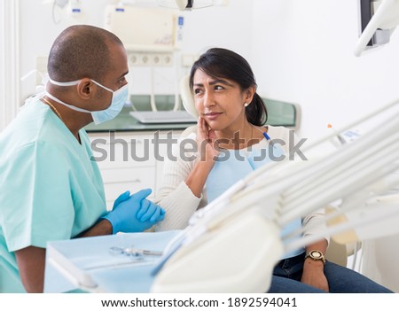 Professional doctor man talking with patient in medical chair