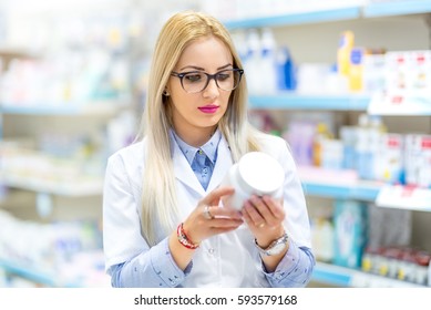 Professional Doctor, Medical Nurse And Pharmacist Reading The Drug Label In Pharmacy