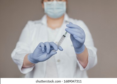 

Professional doctor with medical syringe in hands, getting ready for injection
