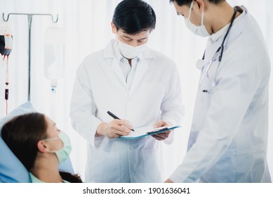 professional doctor and nurse are wearing PPE suit protection and looking for coronavirus covid-19 virus infected patient's in hospital laboratory - Shutterstock ID 1901636041