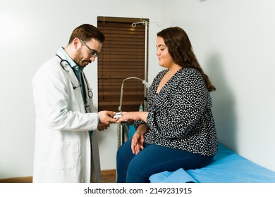 Professional Doctor Putting An Oximeter To Check The Blood Oxygen Levels Of A Sick Young Woman