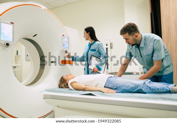Professional Doctor
Radiologist In Medical Laboratory Controls magnetic resonance
imaging or computed tomography or PET Scan with Female Patient
Undergoing
Procedure.