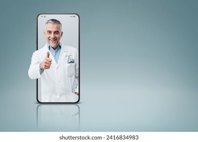 Professional doctor in a smartphone giving a thumbs up videocall and smiling, online doctor and telemedicine service concept - Powered by Shutterstock