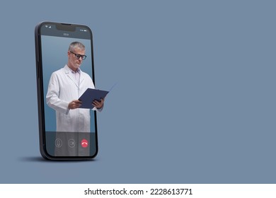 Professional doctor in a smartphone videocall and checking medical records, online doctor and telemedicine concept - Powered by Shutterstock