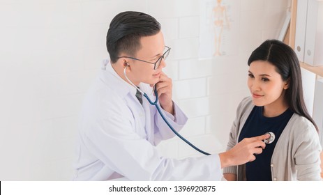 Professional Doctor Wearing White Coat Using Stethoscope To Examine Woman Patient In Hospital Background.Concept Of Disease Treatment And Health Care In Hospitals.