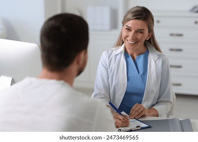 Professional doctor working with patient at white table in hospital - Powered by Shutterstock