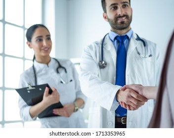 Professional Doctors Handshaking At Hospital, Standing Together