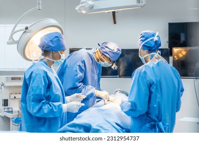 Professional doctors performing surgical operation in operating room. Attractive specialist medic surgeon medical team working and operation sick patient on intensive care patient in hospital ward. - Powered by Shutterstock