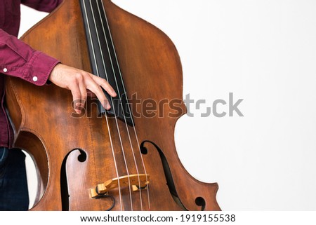 Professional double bass player. Photo shooting in studio. White background