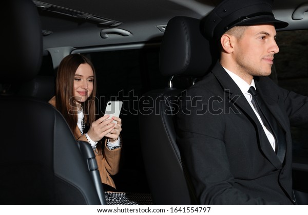 Professional driver and businesswoman in luxury\
car. Chauffeur\
service