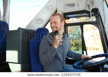 Professional driver making announcement for passengers in bus