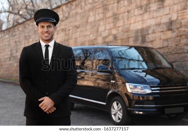 Professional driver near luxury car on street.\
Chauffeur service