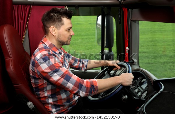 Professional driver
sitting in cab of modern
truck