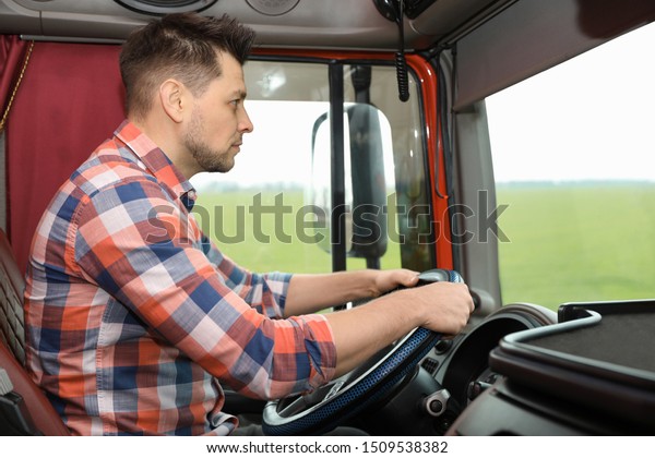 Professional driver\
sitting in cab of modern\
truck