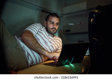 Professional Driver Surfing The Net On Laptop In Truck Cabin At Night.