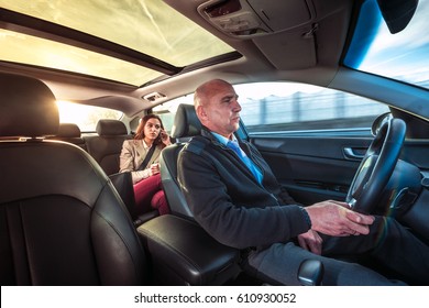 Professional driver, a taxi chauffeur, driving a woman towards her destination.
